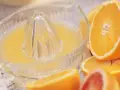 Exprimiendo naranjas en un vaso. ¡No te preocupes, la naranja engorda solo si te la comes entera!
