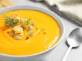 Crema de calabaza y jengibre, decorada con semillas de calabaza, picatostes y eneldo.