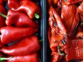 Dos recipientes llenos de pimientos rojos, unos frescos y brillantes, otros pimientos asados con la piel arrugada y un toque tostado.