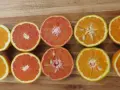 Mitades de naranjas y toronjas en una tabla de madera. La naranja sirve para aportar vitamina C y un sabor refrescante a tus comidas.