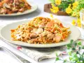 Un delicioso wok de verduras y arroz con trozos de pollo y champiñones, adornado con cebollino fresco.