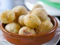 Papas arrugadas en cuenco de barro, un ejemplo del valor nutricional patata, con su piel salada y arrugada.