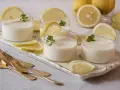 Delicioso postre de lemon curd receta original, servido en vasos con rodajas de limón y menta.