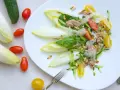 Ensalada de endivias con atún, tomate, pepino y piñones. Fresca y ligera, perfecta para un día soleado.