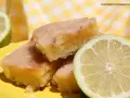 Deliciosos trozos de brownie de limón con glaseado brillante y rodajas de limón fresco.