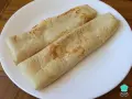 Dos crepes de avena enrollados en un plato blanco, listos para disfrutar.