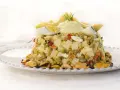 Deliciosa ensaladilla de aguacate con huevo duro, guisantes y mejillones, coronada con una crema suave y rodajas de aguacate fresco.