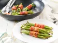 Habichuelas salteadas envueltas en tocino crujiente, listas para servir.
