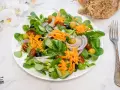 Deliciosa ensalada mediterránea con lechuga, tomate, aceitunas, cebolla morada y zanahoria rallada.
