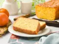 Un delicioso bizcocho de mandarina, recién horneado, con dos rebanadas servidas en un plato blanco.