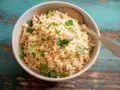 Un tazón de arroz integral esponjoso, adornado con perejil fresco, listo para ser disfrutado.