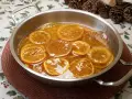 Rodajas de naranjas naturales confitadas en almíbar, un delicioso postre listo para disfrutar.
