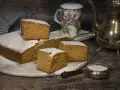 Un delicioso bizcocho de mango, espolvoreado con azúcar glas, listo para disfrutar con una taza de té.
