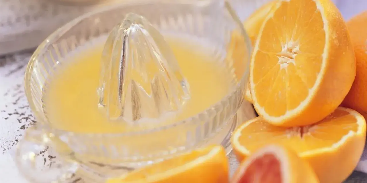 Exprimiendo naranjas en un vaso. ¡No te preocupes, la naranja engorda solo si te la comes entera!