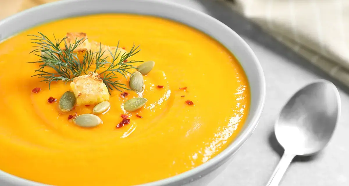 Crema de calabaza y jengibre, decorada con semillas de calabaza, picatostes y eneldo.