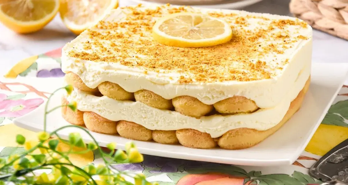 Delicioso tiramisú de limón en capas, adornado con galletas y una rodaja de limón.