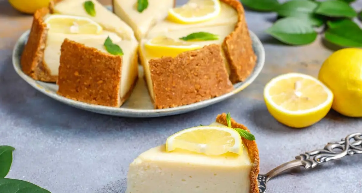 Deliciosa tarta de limón sin horno, cremosa y refrescante, decorada con rodajas de limón y hojas de menta.
