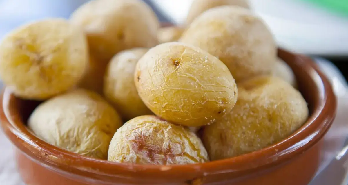 Papas arrugadas en cuenco de barro, un ejemplo del valor nutricional patata, con su piel salada y arrugada.