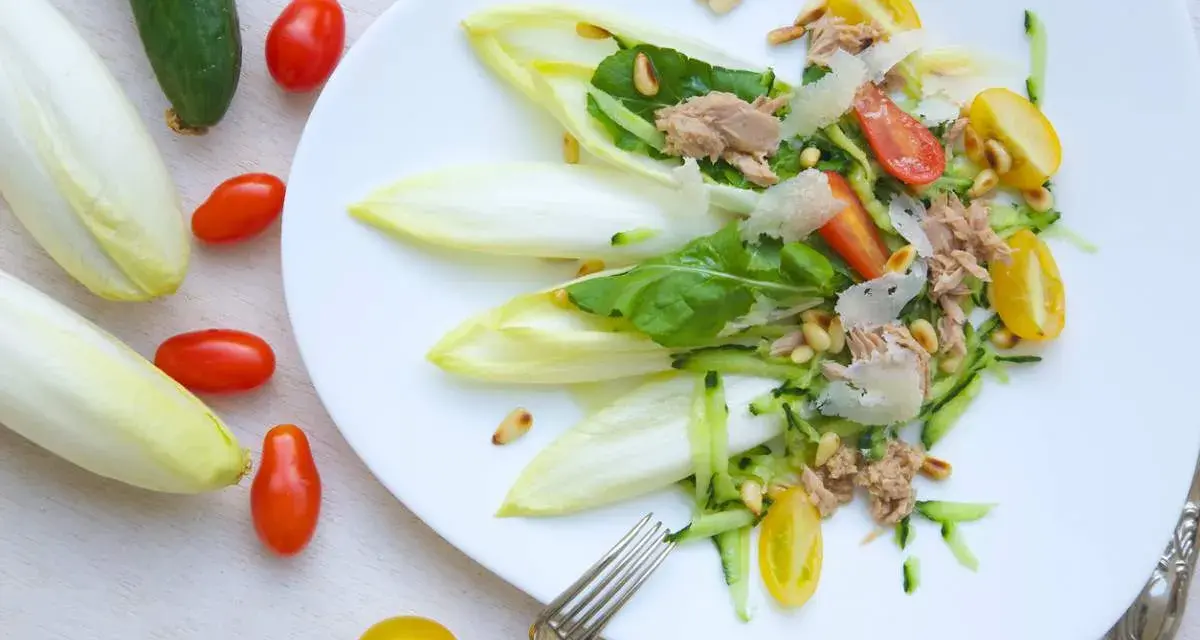 Ensalada de endivias con atún, tomate, pepino y piñones. Fresca y ligera, perfecta para un día soleado.