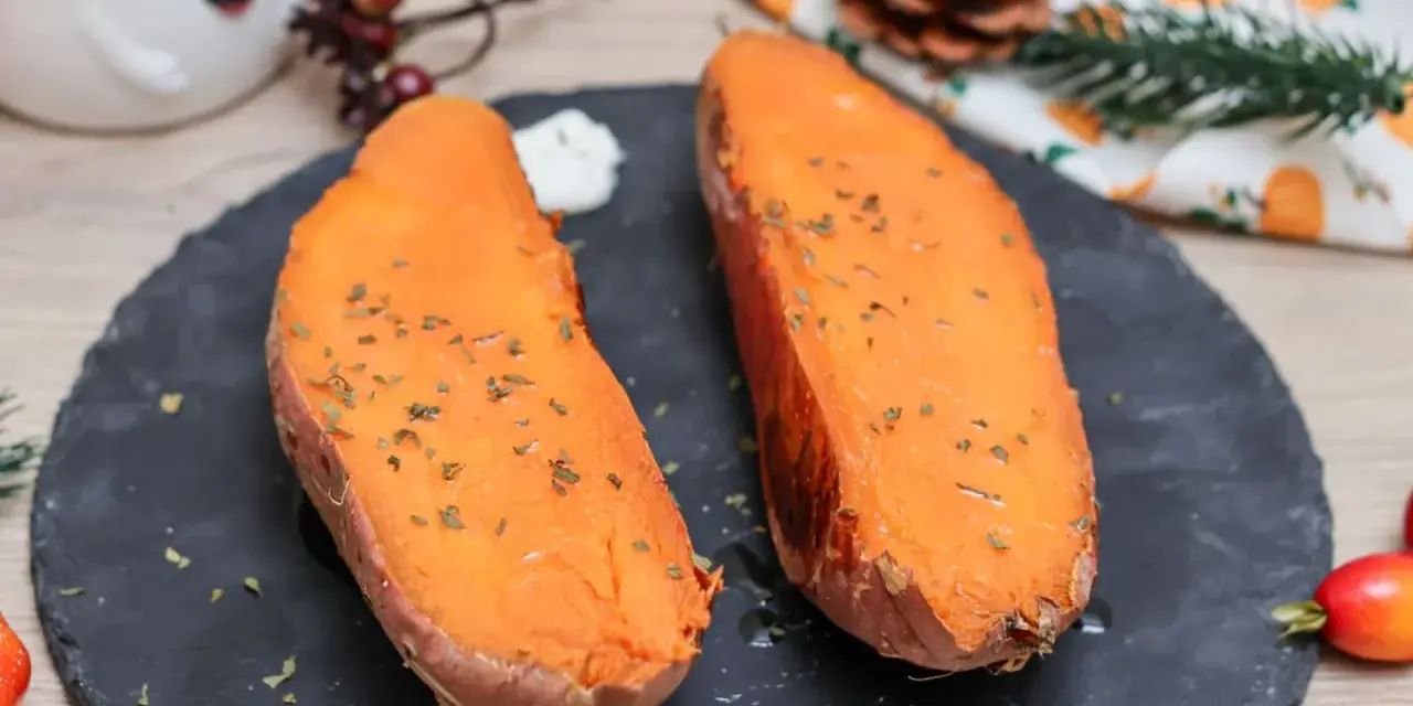 Dos mitades de boniato al horno, tiernas y doradas, con hierbas picadas y un toque de crema. ¡Un placer sencillo!