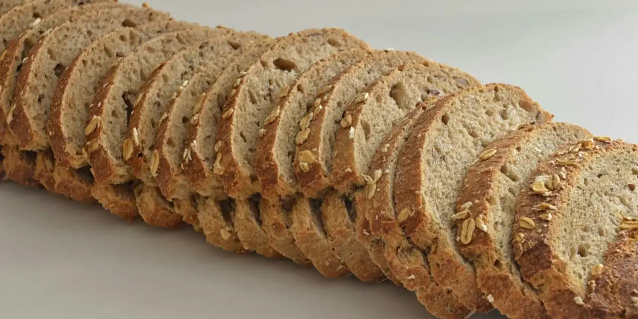 Rebanadas de pan de espelta con avena y semillas, listas para un desayuno saludable.