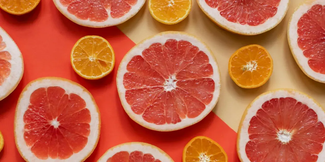 Pomelos y mandarinas cortados por la mitad, listos para disfrutar de los beneficios del pomelo en ayunas.