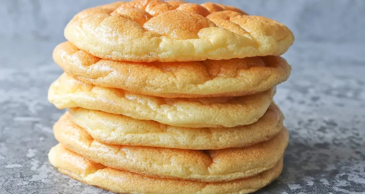 Una pila de pan nube, esponjosos y dorados, parecen nubes comestibles listas para ser disfrutadas.
