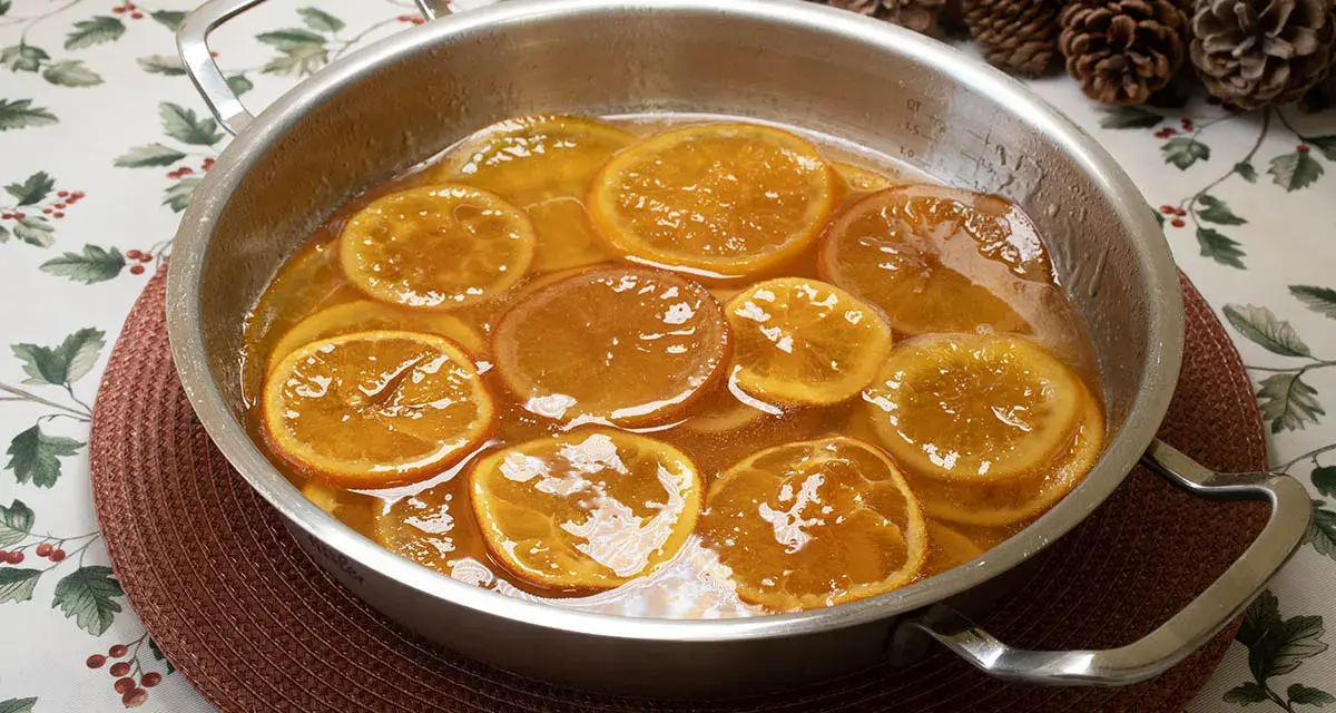 Rodajas de naranjas naturales confitadas en almíbar, un delicioso postre listo para disfrutar.