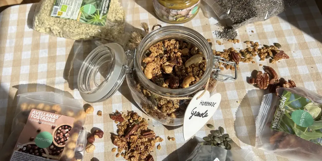Ingredientes para una deliciosa receta de granola casera: avellanas tostadas, semillas de cáñamo, chía, calabaza, nuez pecan y crema de pistacho.