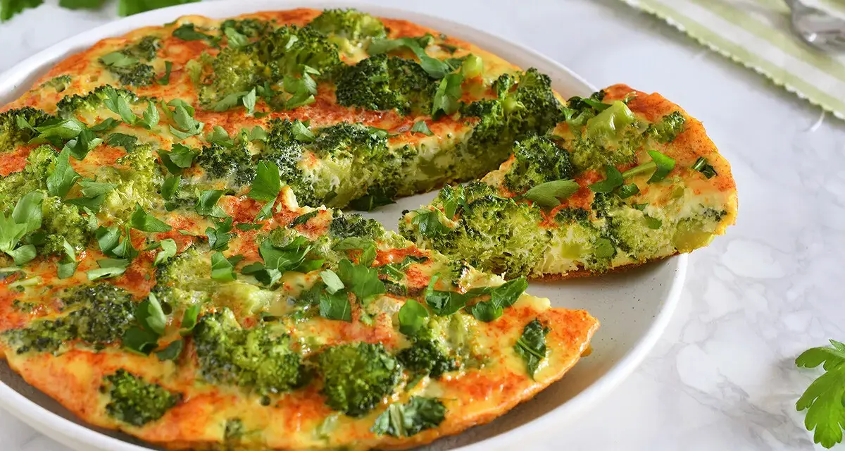 Deliciosa tortilla de brócoli, recién hecha y espolvoreada con perejil fresco. Un plato saludable y sabroso.