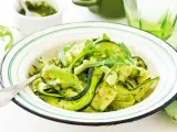 Deliciosa ensalada de calabacín en espiral con pesto y rúcula, adornada con piñones. Un plato fresco y vibrante.