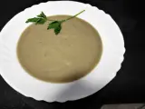 Crema de berenjena suave y sedosa, decorada con una ramita de perejil fresco, lista para disfrutar.