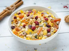 Un tazón lleno de muesli casero, con frutos secos, cerezas, albaricoques y semillas.