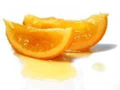 Dos rodajas de naranja confitada brillan con dulzura, bañadas en un almíbar dorado sobre fondo blanco.