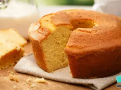 Un delicioso bizcocho sin azúcar, dorado y esponjoso, con una rebanada aparte. Perfecto para un desayuno o merienda saludable.