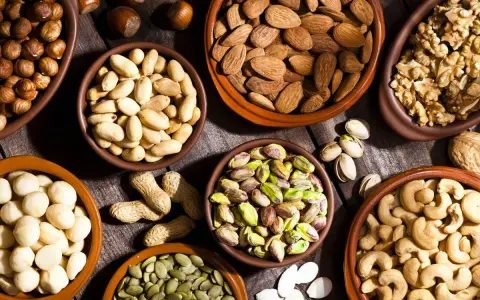 Variedad de frutos secos en cuencos: almendras, nueces, pistachos, anacardos, cacahuetes, avellanas y semillas de calabaza. ¡Perfectos para activar frutos secos!