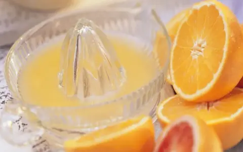 Exprimiendo naranjas en un vaso. ¡No te preocupes, la naranja engorda solo si te la comes entera!