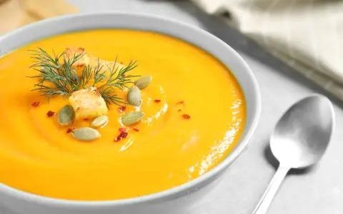 Crema de calabaza y jengibre, decorada con semillas de calabaza, picatostes y eneldo.