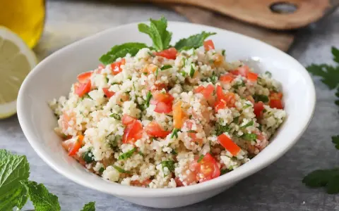 Delicioso tabule receta, con cuscús, tomate fresco, perejil y menta, listo para servir.