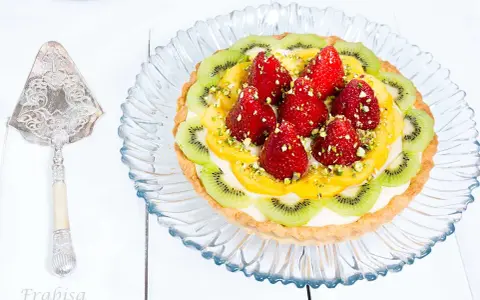 Tarta de frutas con fresas, kiwi y mango, decorada con pistachos. ¡Una delicia visual y gustativa!