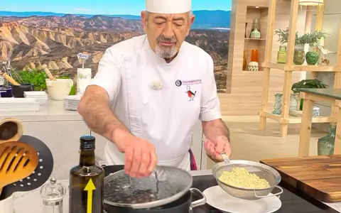 Chef muestra cómo cocinar quinoa, drenando el grano cocido en un colador.