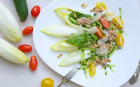 Ensalada de endivias con atún, tomate, pepino y piñones. Fresca y ligera, perfecta para un día soleado.
