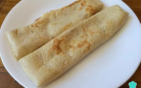 Dos crepes de avena enrollados en un plato blanco, listos para disfrutar.