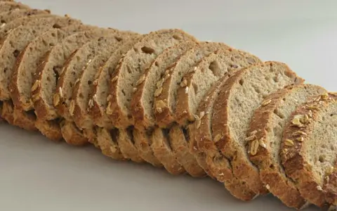 Rebanadas de pan de espelta con avena y semillas, listas para un desayuno saludable.
