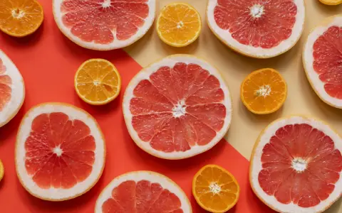 Pomelos y mandarinas cortados por la mitad, listos para disfrutar de los beneficios del pomelo en ayunas.