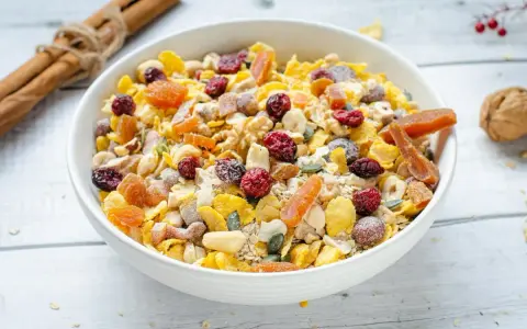 Un tazón lleno de muesli casero, con frutos secos, cerezas, albaricoques y semillas.