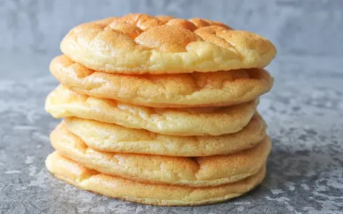 Una pila de pan nube, esponjosos y dorados, parecen nubes comestibles listas para ser disfrutadas.
