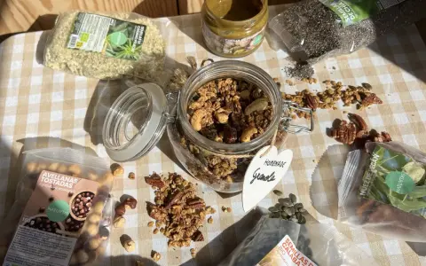 Ingredientes para una deliciosa receta de granola casera: avellanas tostadas, semillas de cáñamo, chía, calabaza, nuez pecan y crema de pistacho.