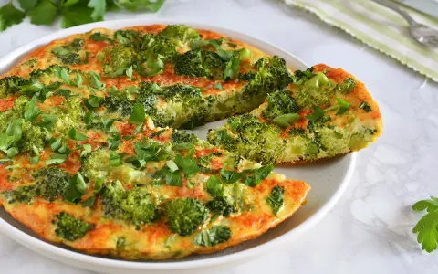 Deliciosa tortilla de brócoli, recién hecha y espolvoreada con perejil fresco. Un plato saludable y sabroso.