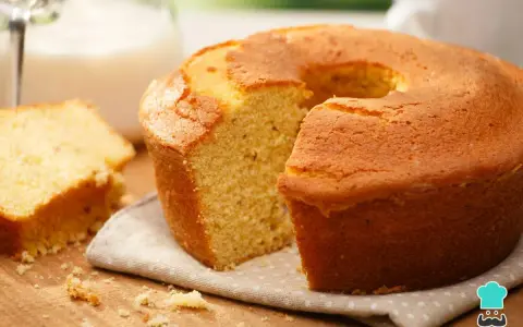 Un delicioso bizcocho sin azúcar, dorado y esponjoso, con una rebanada aparte. Perfecto para un desayuno o merienda saludable.